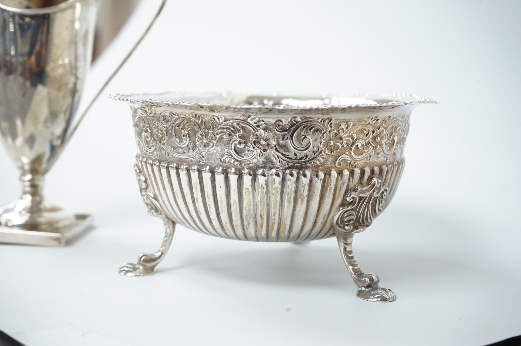 A late Victorian silver sugar basin, by Robert Harper, London, 1879, diameter 13.2cm, together with an Edwardian silver helmet shaped cream jug, Saunders & Shepherd, Chester, 1905, 15cm, 9.1oz.